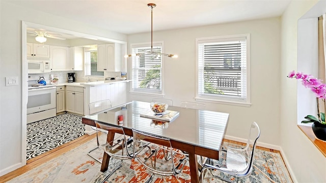 dining space featuring light wood-type flooring, ceiling fan, a healthy amount of sunlight, and sink