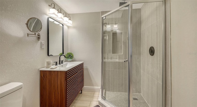 bathroom featuring tile patterned floors, vanity, toilet, and walk in shower