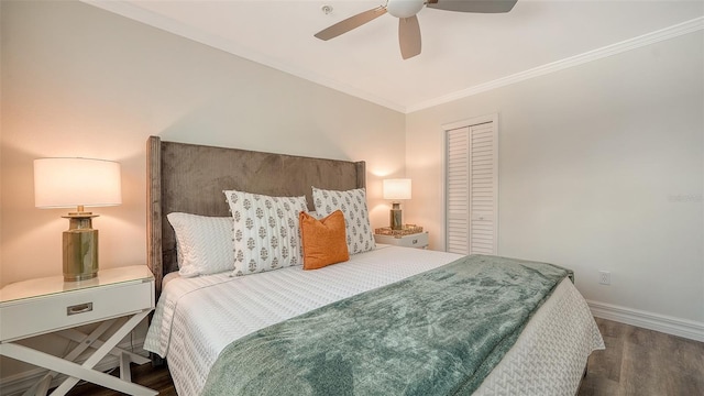 bedroom with dark hardwood / wood-style flooring, ceiling fan, a closet, and ornamental molding