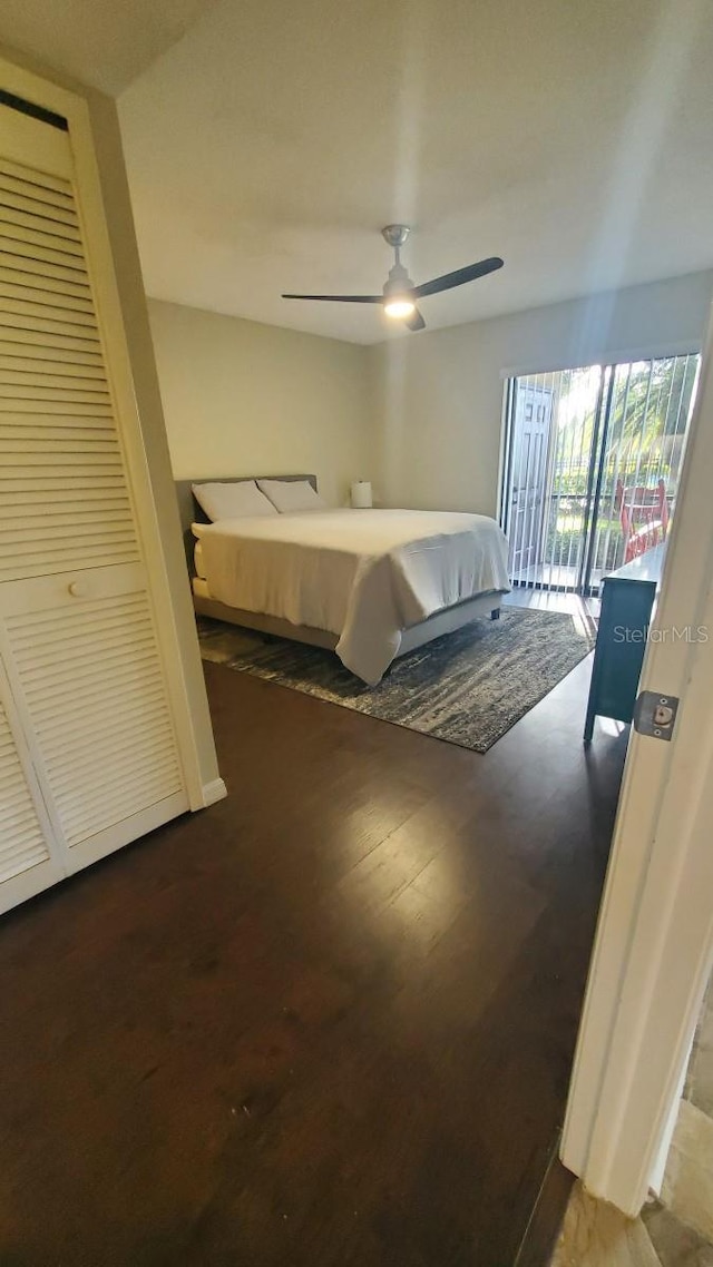 bedroom featuring access to exterior, ceiling fan, a closet, and dark wood-type flooring