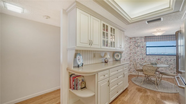 kitchen featuring white cabinetry, light hardwood / wood-style flooring, and a textured ceiling