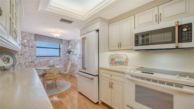 kitchen featuring white appliances, crown molding, light hardwood / wood-style flooring, decorative backsplash, and a textured ceiling