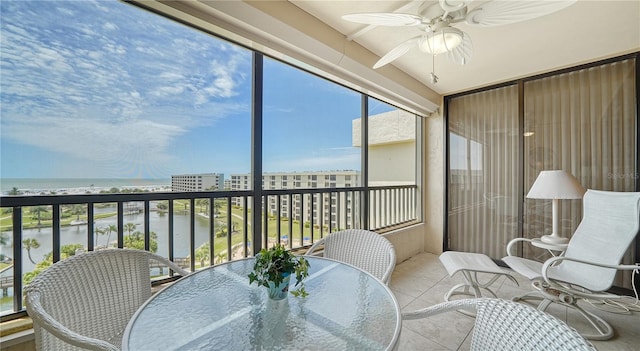 sunroom featuring a water view and ceiling fan