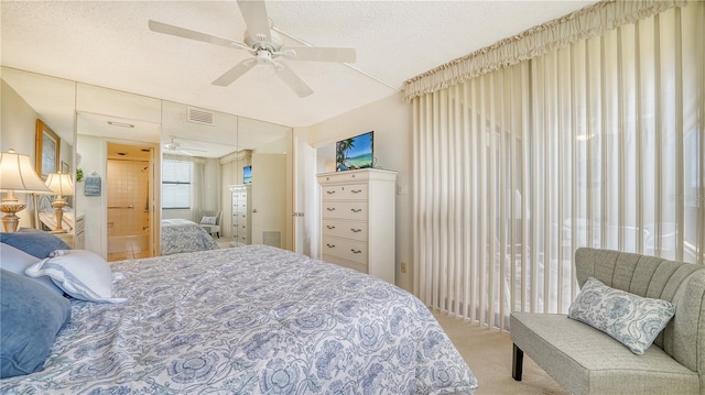 carpeted bedroom with ceiling fan and a textured ceiling