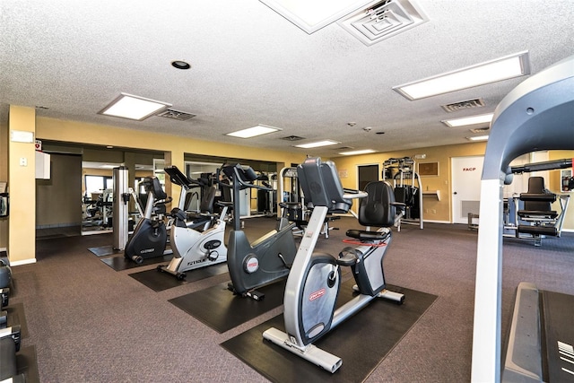 exercise room featuring a textured ceiling, visible vents, and baseboards