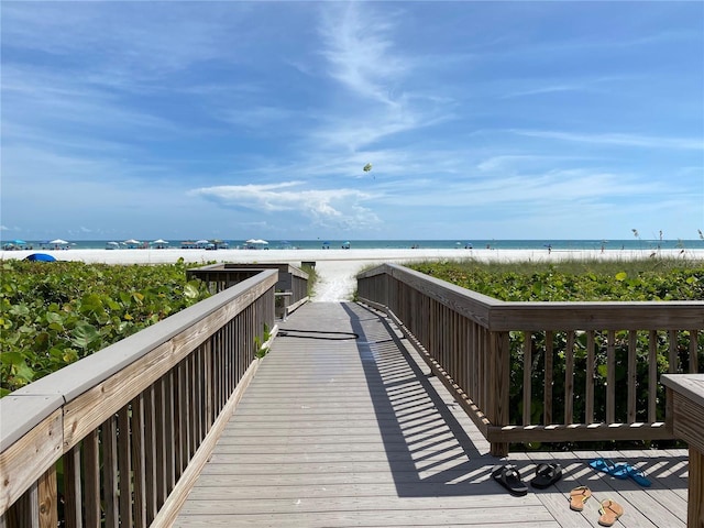 view of home's community with a water view and a beach view
