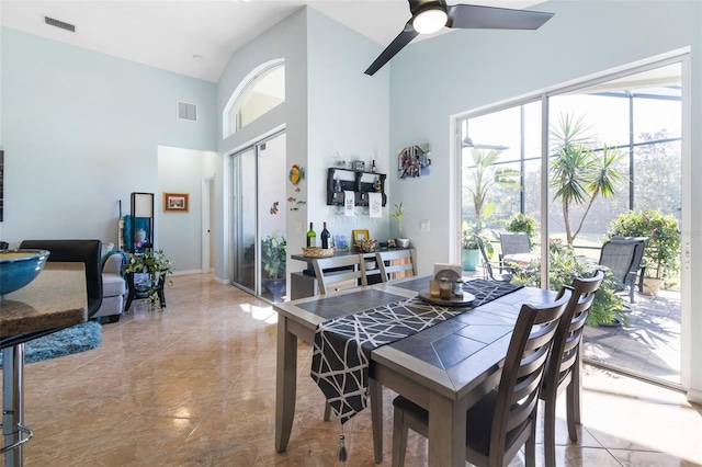 dining room with high vaulted ceiling and ceiling fan