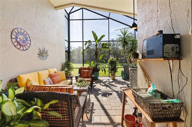 view of patio with outdoor lounge area and glass enclosure