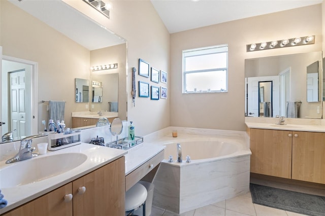 bathroom with tile patterned floors, vanity, a bathing tub, and vaulted ceiling