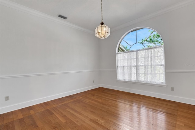 unfurnished room featuring hardwood / wood-style floors, ornamental molding, and an inviting chandelier