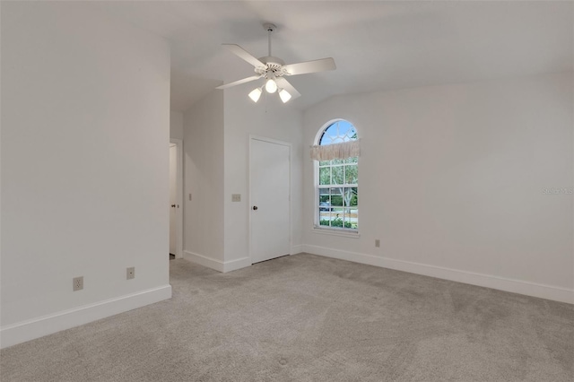 empty room featuring ceiling fan, light carpet, and vaulted ceiling