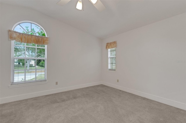 unfurnished room featuring light colored carpet, vaulted ceiling, and ceiling fan