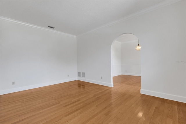 empty room with light hardwood / wood-style floors and crown molding