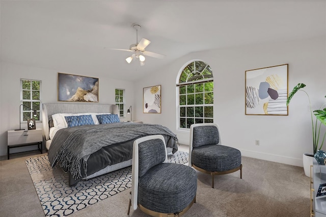 bedroom featuring multiple windows, ceiling fan, carpet floors, and lofted ceiling