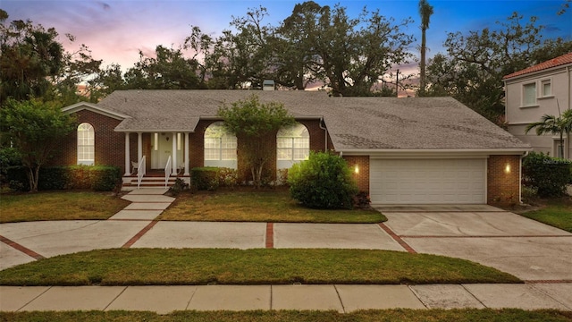 view of front of home with a garage and a lawn