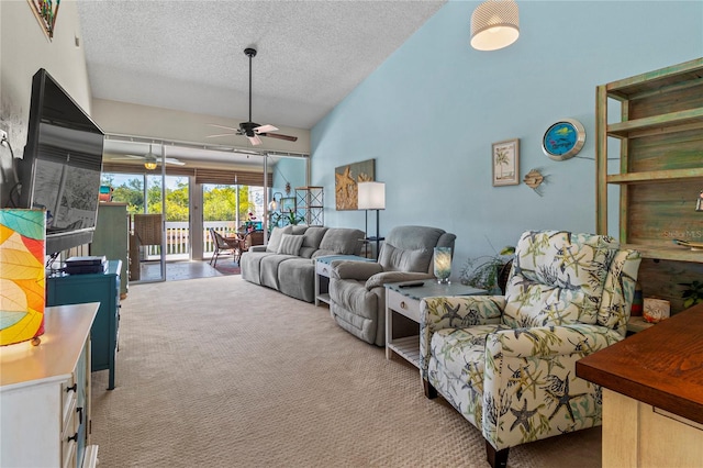 living room featuring a textured ceiling, ceiling fan, light carpet, and vaulted ceiling