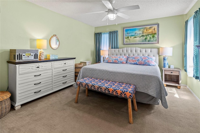 carpeted bedroom with ceiling fan, a textured ceiling, and multiple windows