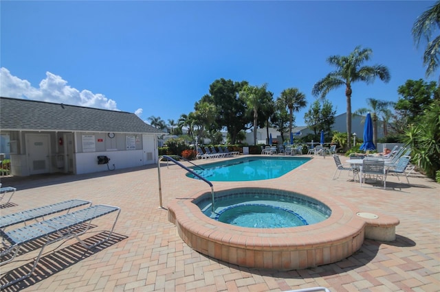 view of pool with a patio and a hot tub