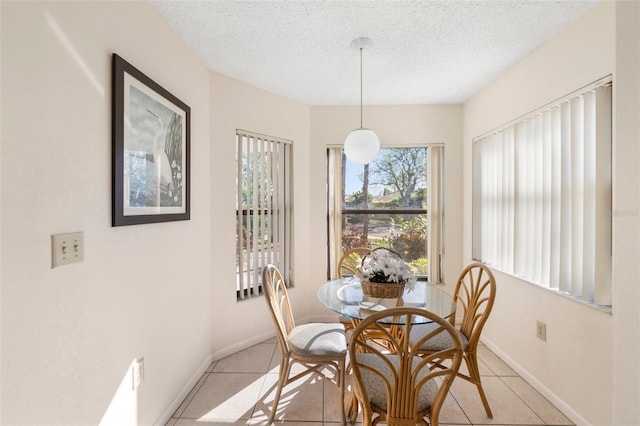 dining area with light tile patterned floors and a textured ceiling