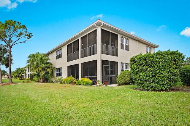 rear view of property with a yard and a sunroom