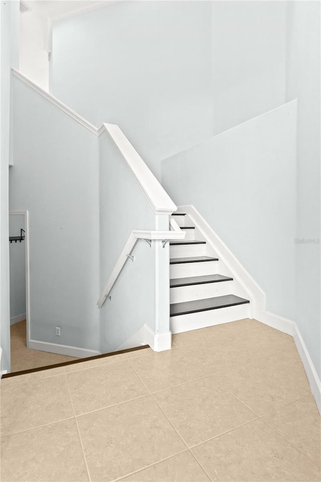 stairway with tile patterned floors