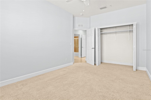 unfurnished bedroom with light carpet, a closet, and ceiling fan