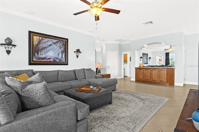 tiled living room with crown molding and ceiling fan