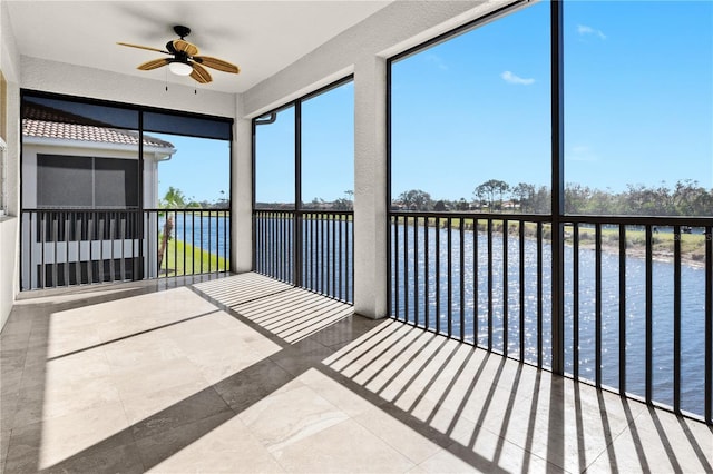 unfurnished sunroom with a water view and ceiling fan