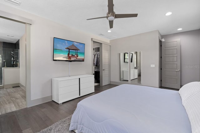 bedroom with ceiling fan, a closet, dark wood-type flooring, and a spacious closet