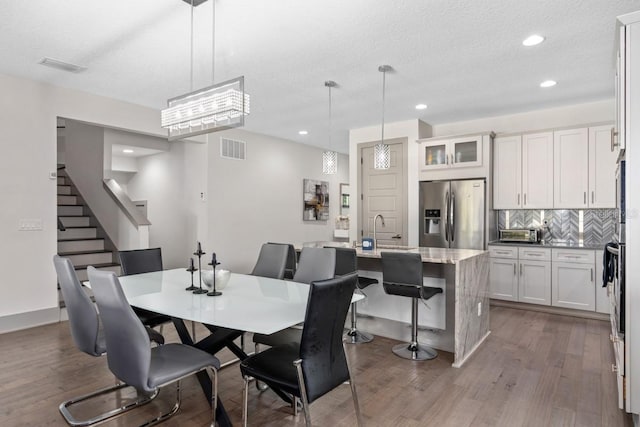 dining room with wood-type flooring, a textured ceiling, and sink