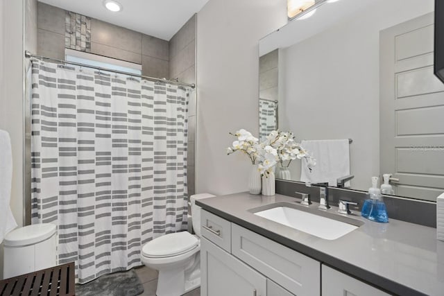 bathroom featuring tile patterned flooring, vanity, toilet, and curtained shower