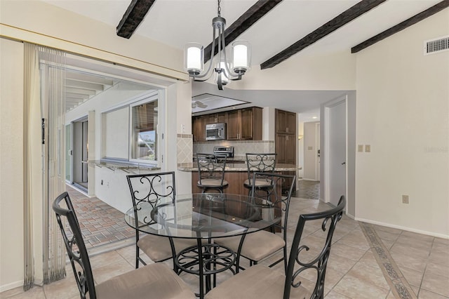 tiled dining space featuring beamed ceiling and a chandelier