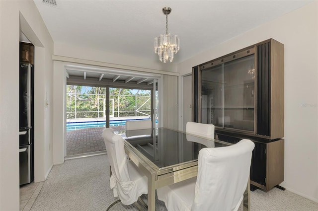 dining space featuring light colored carpet and a chandelier