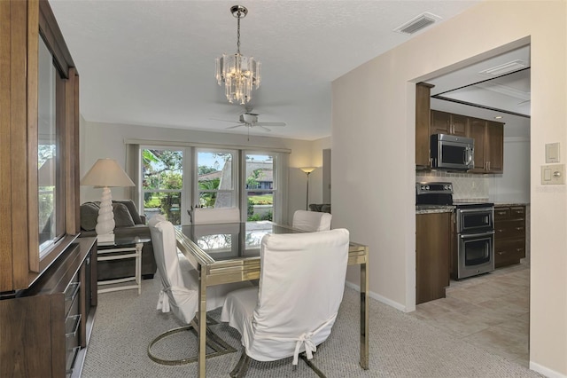 tiled dining room featuring ceiling fan with notable chandelier