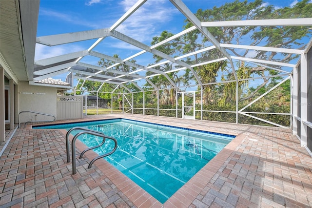 view of swimming pool featuring a lanai and a patio area