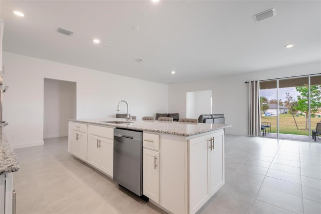 kitchen featuring white cabinetry, sink, light stone counters, stainless steel dishwasher, and a center island with sink