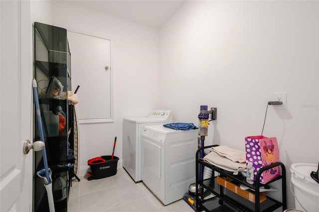 clothes washing area featuring washing machine and dryer and light tile patterned floors