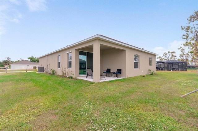 rear view of house featuring central AC unit, a yard, and a patio