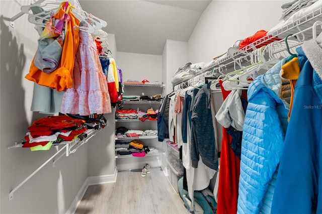 walk in closet featuring wood-type flooring and lofted ceiling