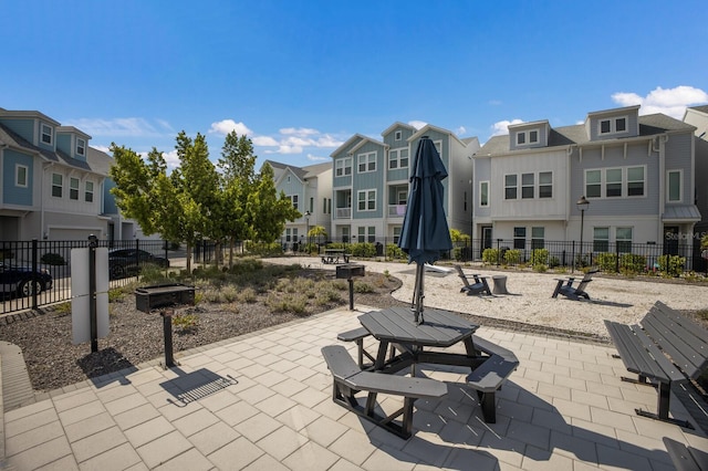 view of home's community featuring a residential view, fence, and a patio