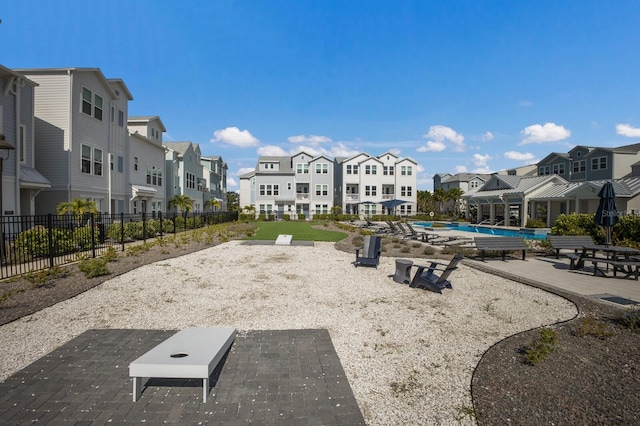 view of property's community featuring a patio area, a residential view, fence, and a pool