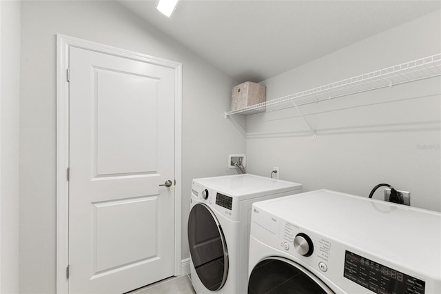 laundry room featuring washer and dryer and light tile patterned flooring