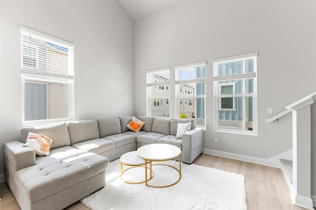 living room featuring a high ceiling and light wood-type flooring