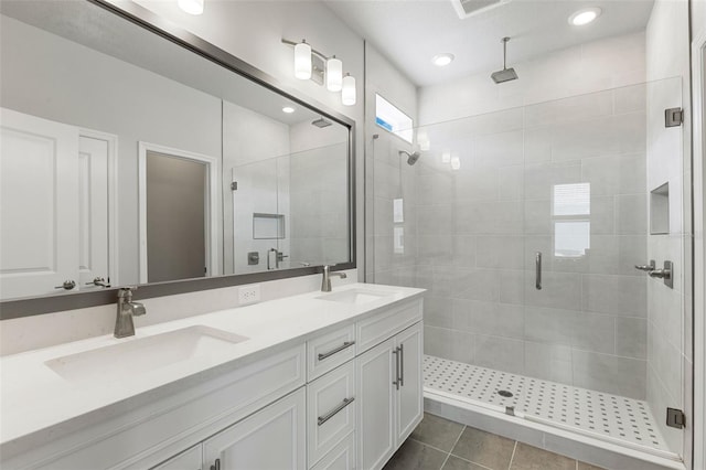 bathroom with tile patterned flooring, vanity, and walk in shower