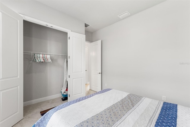 bedroom featuring a closet, carpet flooring, visible vents, and baseboards