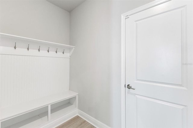 mudroom featuring light wood finished floors and baseboards