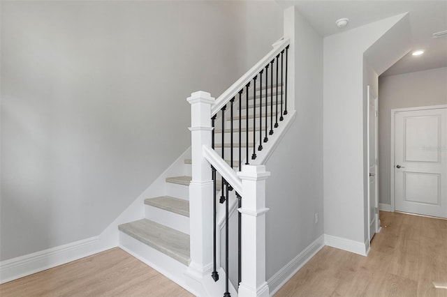 stairs featuring wood finished floors and baseboards