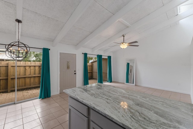 kitchen featuring light stone counters, ceiling fan, gray cabinetry, and light tile patterned flooring