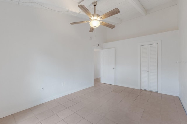 unfurnished bedroom featuring high vaulted ceiling, ceiling fan, light tile patterned floors, beam ceiling, and a closet