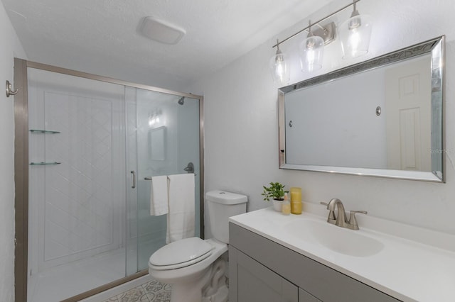 bathroom with a textured ceiling, vanity, toilet, and walk in shower